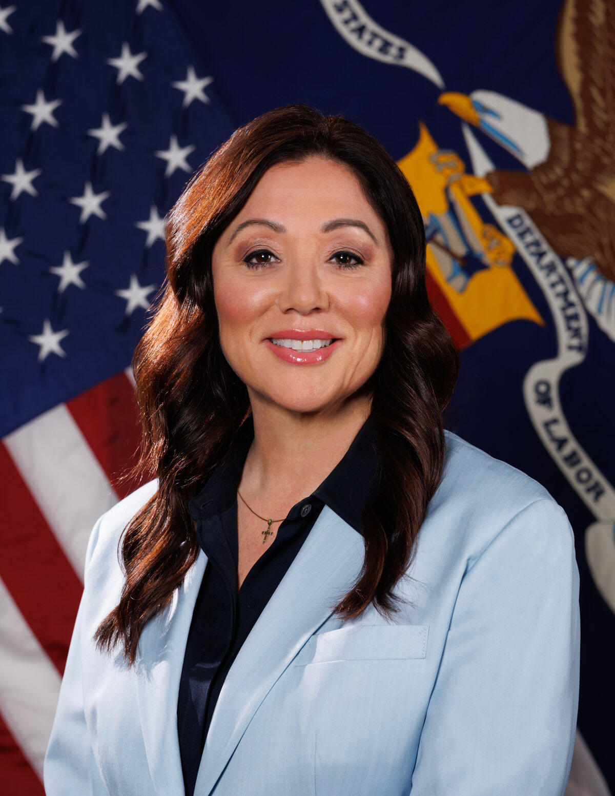 Lori Chavez-DeRemer in her 2025 official Department of Labor portrait, standing before U.S. and departmental flags.