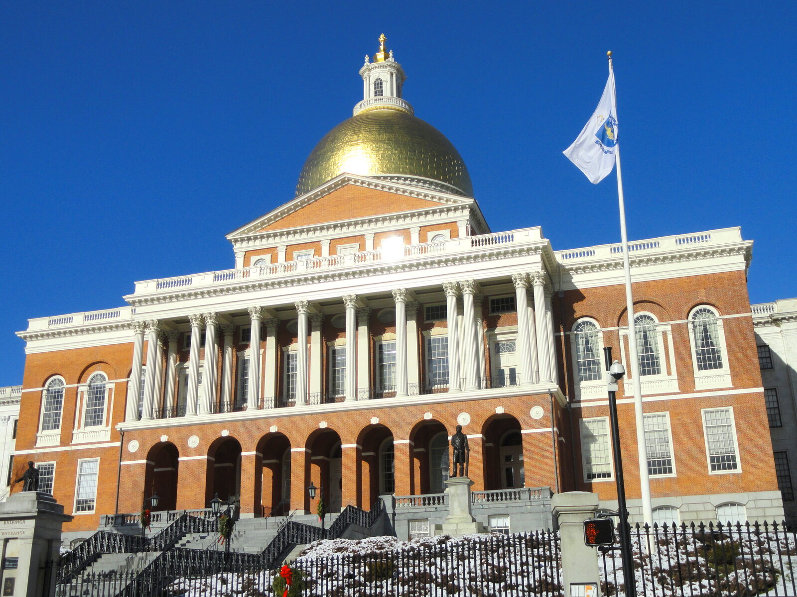 Massachusetts State House in Boston, with its gold dome, columns and state flag.
