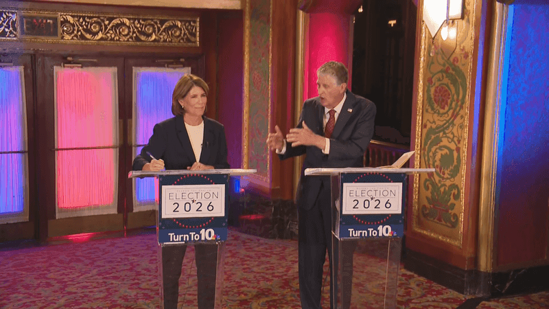 Helena Foulkes and Rhode Island Gov. Dan McKee stand side by side at podiums during a 2026 Democratic primary debate.