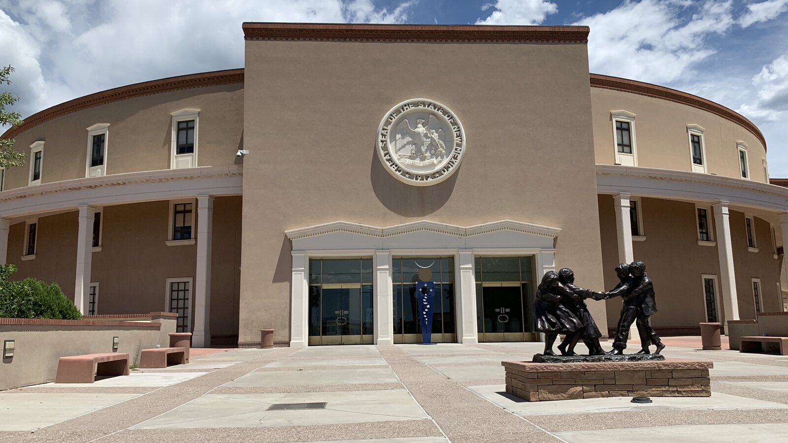 Front entrance of the New Mexico State Capitol in Santa Fe, with the state seal above the doors.