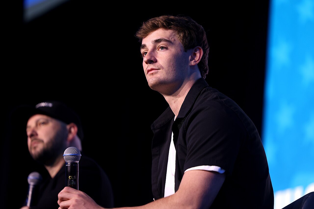 Independent journalist Nick Shirley holds a microphone during a July 2026 public event.